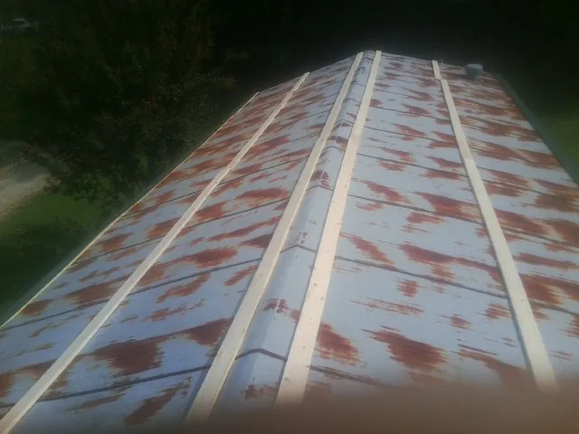 Rusted metal roof panels with new wood purlins before replacement — Storm Damage Roof Repair in Hartsville by Roofing Brothers